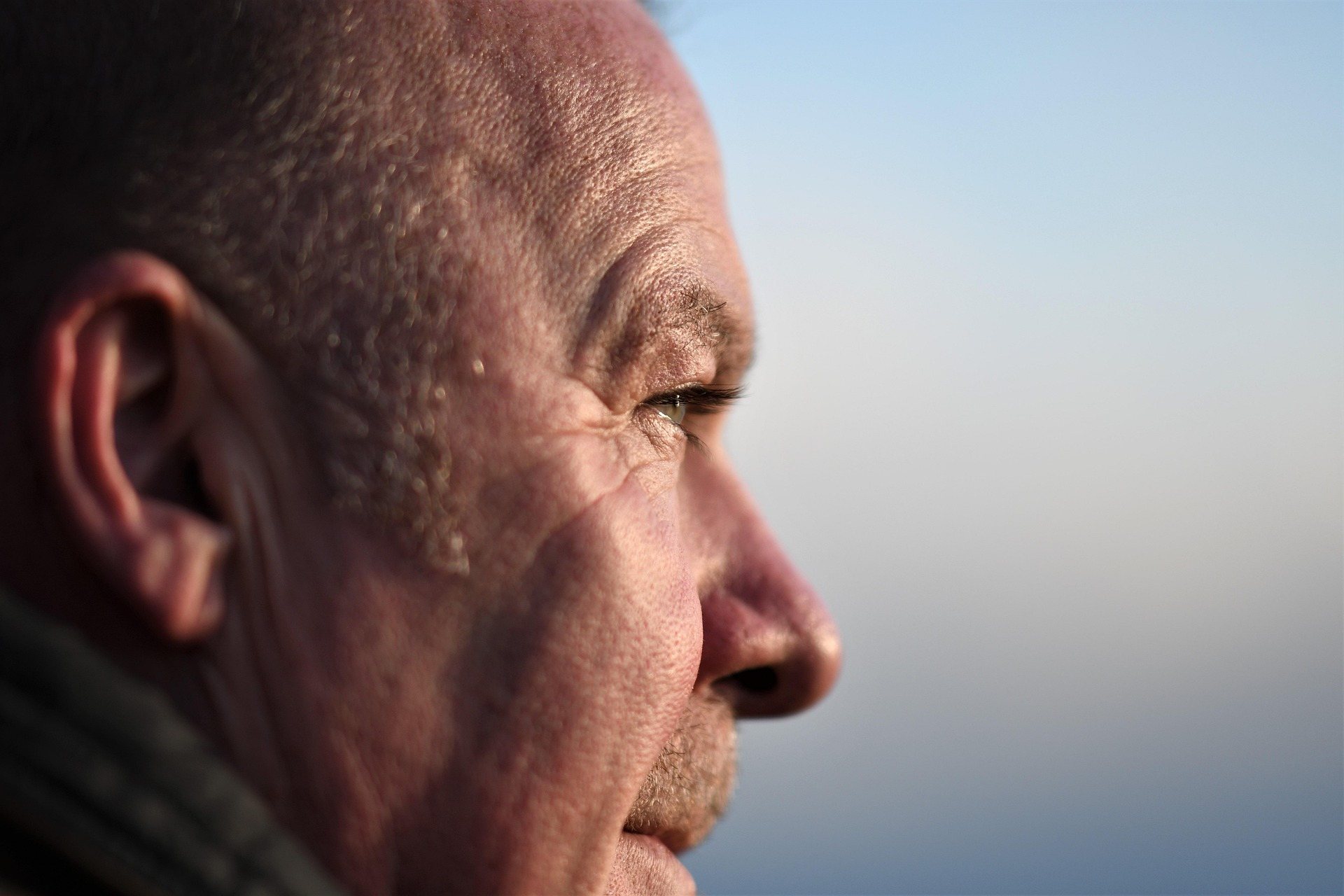 A man looking out towards the horizon in soft morning light